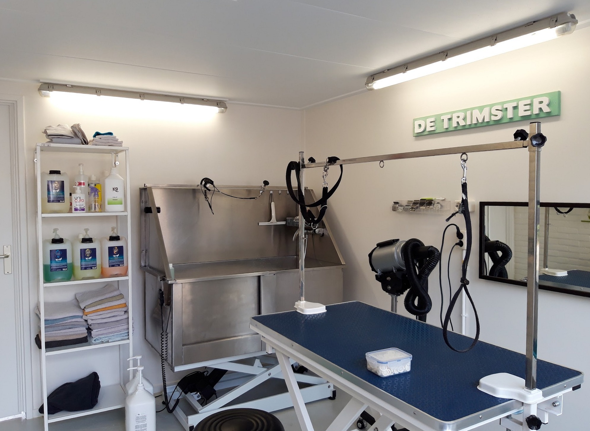 De salon met mintgroen bord De Trimster, wasplaats en trimtafels